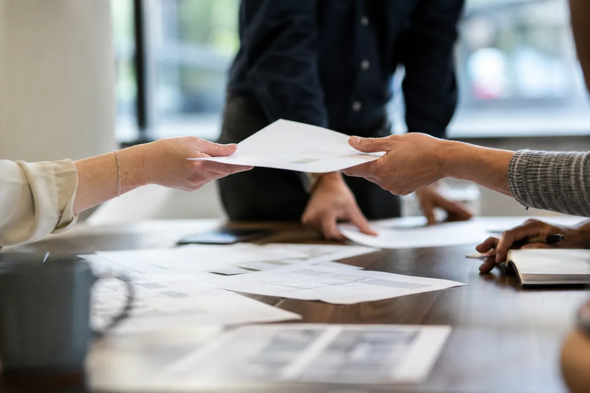 Réunion d&rsquo;équipe autour d&rsquo;une table avec échange de documents